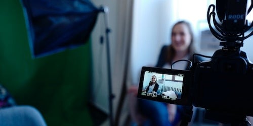 Law firm online marketing: Woman sitting in a chair and being recorded by a camera.